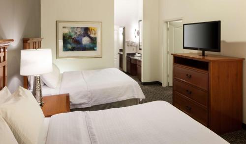 a hotel room with two beds and a flat screen tv at Homewood Suites by Hilton Agoura Hills in Agoura Hills