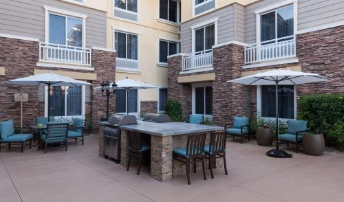 a patio with a table and chairs and umbrellas at Homewood Suites by Hilton Agoura Hills in Agoura Hills