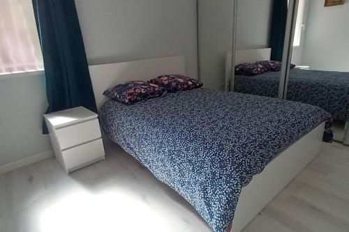 ein Schlafzimmer mit einem Bett mit Kissen und einem Spiegel in der Unterkunft appartement centre ville avec terrasse in Sanary-sur-Mer