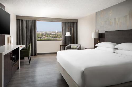 a hotel room with a bed and a desk and a window at Dallas-Addison Marriott Quorum by the Galleria in Dallas