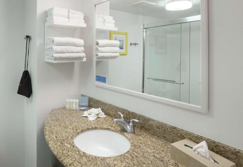 a bathroom with a sink and a mirror and towels at Hampton Inn Austin Round Rock in Round Rock