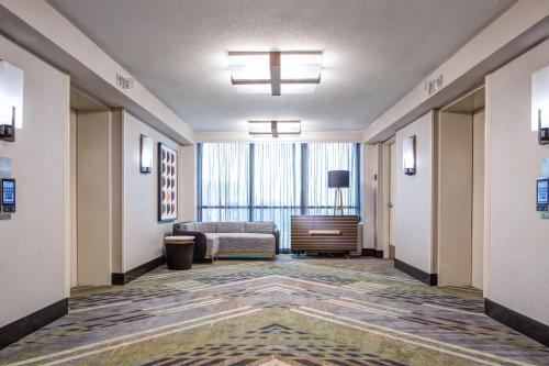 a hotel room hallway with a bed and a window at Dallas-Addison Marriott Quorum by the Galleria in Addison