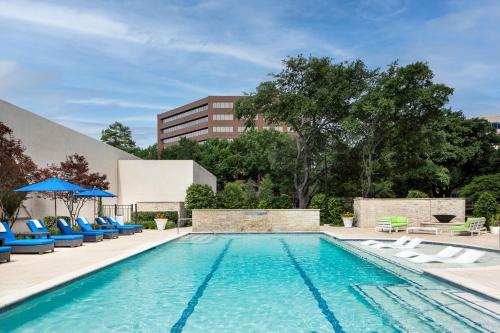 達拉斯的住宿－達拉斯艾迪森科然姆商業街廊萬豪酒店，一座带椅子的游泳池以及一座建筑