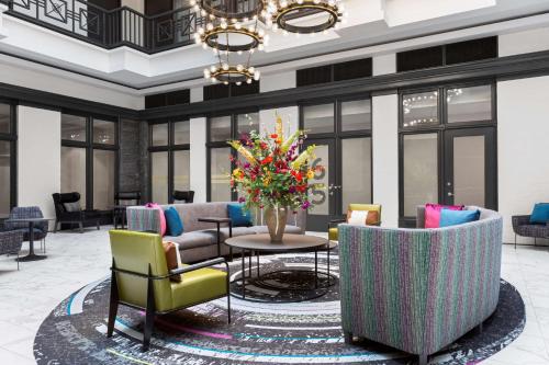 Homewood Suites by Hilton Nashville Downtown في ناشفيل: لوبي مع كراسي وطاولة مع إناء من الزهور