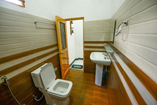 a bathroom with a toilet and a sink at Dambulla Kings Inn in Dambulla