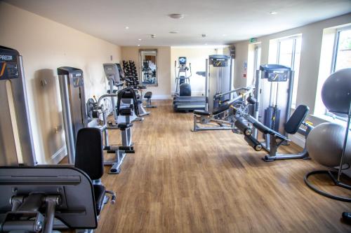 a gym with several treadmills and cardio machines at Best Western Brome Grange Hotel in Brome