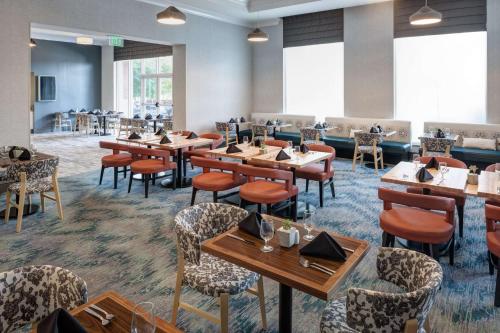 a restaurant with tables and chairs in a room at Hilton Garden Inn Nashville Vanderbilt in Nashville