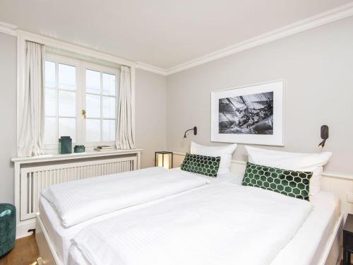 two beds in a bedroom with white walls and windows at Hansenhoog-2 in Kampen