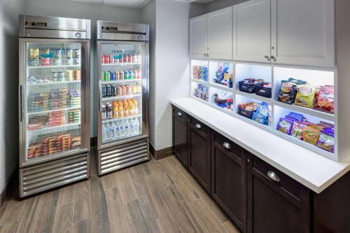 a kitchen with two refrigerators with food and drinks at Homewood Suites by Hilton Austin NW near The Domain in Austin