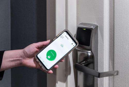 a person holding a smart phone in front of a door at Homewood Suites by Hilton Austin NW near The Domain in Austin