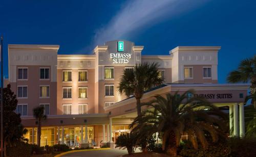 a hotel building with a sign that reads business suites at Embassy Suites by Hilton Destin Miramar Beach in Destin