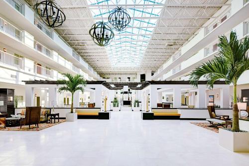 德斯坦Embassy Suites by Hilton Destin Miramar Beach的大型大堂设有椅子和棕榈树