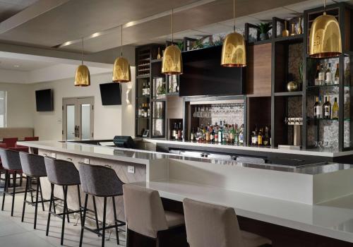 a bar with a row of bar stools at Hilton Garden Inn Las Colinas in Irving