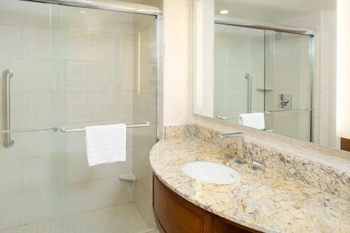 a bathroom with a sink and a shower at Embassy Suites by Hilton Destin Miramar Beach in Destin