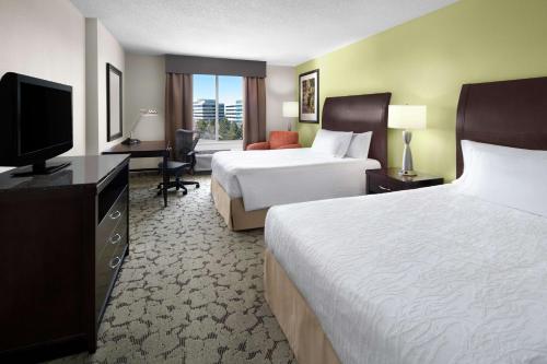um quarto de hotel com duas camas e uma televisão de ecrã plano em Hilton Garden Inn Denver Highlands Ranch em Highlands Ranch