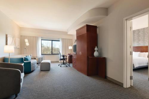 a hotel room with a bed and a desk at Courtyard Charlotte Airport North in Charlotte