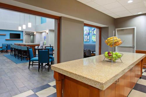 a cafeteria with a counter with a bowl of fruit on it at Hampton Inn & Suites Clovis Airport North in Clovis