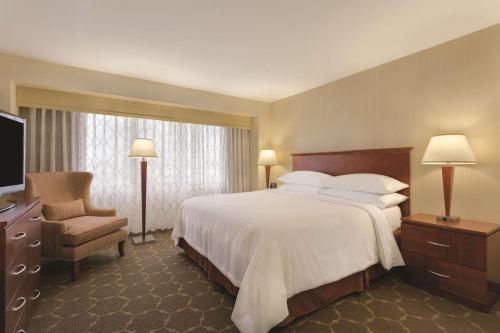 a hotel room with a large bed and a chair at Embassy Suites Denver Tech Center in Centennial