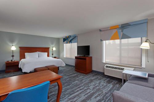 Hampton Inn & Suites Clovis Airport North في كلوفيس: غرفه فندقيه بسرير وطاولة واريكه
