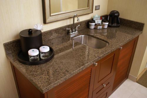 um balcão de cozinha com um lavatório e um espelho em Embassy Suites Denver Tech Center em Centennial