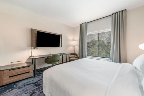 a hotel room with a bed and a desk and a window at Fairfield by Marriott Inn & Suites Knoxville Clinton in Clinton