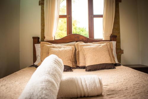 a bed with white sheets and pillows in front of a window at El Pozzo Hotel Campestre in Villa de Leyva