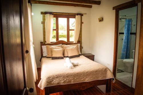a bedroom with a bed with a teddy bear on it at El Pozzo Hotel Campestre in Villa de Leyva