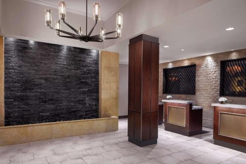 a lobby with a stone wall and a chandelier at Embassy Suites Fort Worth - Downtown in Fort Worth