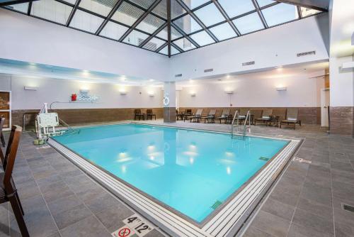 a large swimming pool in a large room with tables and chairs at Hilton Indianapolis Hotel & Suites in Indianapolis