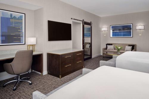 a hotel room with a bed and a desk with a computer at Hilton Indianapolis Hotel & Suites in Indianapolis