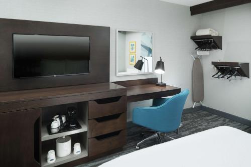 a hotel room with a television and a blue chair at Hampton Inn Los Angeles Santa Clarita in Santa Clarita