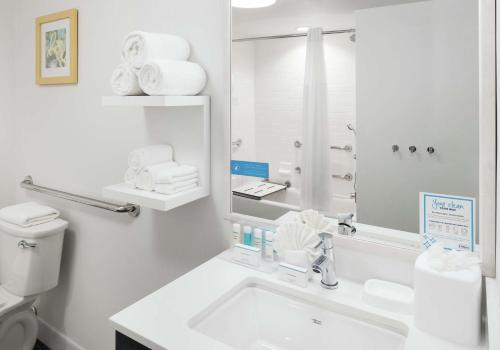 La salle de bains blanche est pourvue d'un lavabo et d'un miroir. dans l'établissement Hampton Inn Los Angeles Santa Clarita, à Santa Clarita