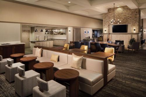 vestíbulo con sofá, mesas y sillas en Homewood Suites by Hilton Lubbock en Lubbock
