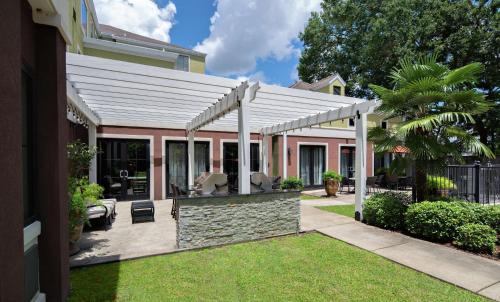 a patio with a white pergola on a house at Homewood Suites Lafayette-Airport in Lafayette