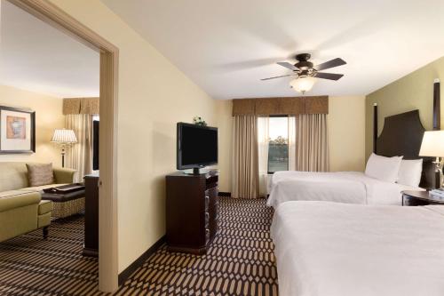 a hotel room with two beds and a flat screen tv at Homewood Suites Lafayette-Airport in Lafayette