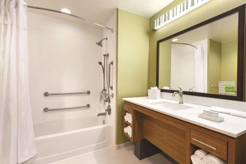 y baño con bañera, lavamanos y ducha. en Home2 Suites by Hilton Parc Lafayette en Lafayette