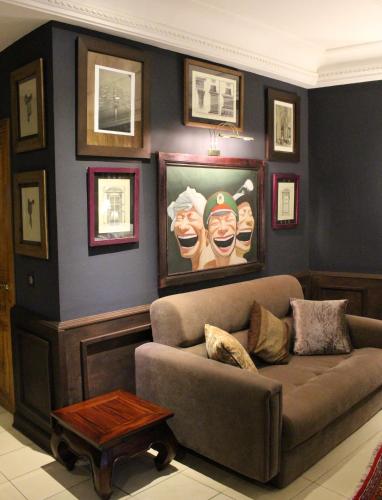 a living room with a couch and pictures on the wall at Le Loft in Bamako