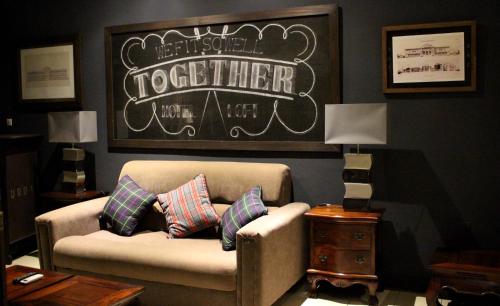 a living room with a couch and a sign on the wall at Le Loft in Bamako