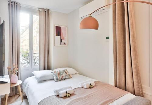 une chambre avec un lit avec deux ours en peluche dessus dans l'établissement Cozy and practical apt in 10th arr - PARIS, à Paris