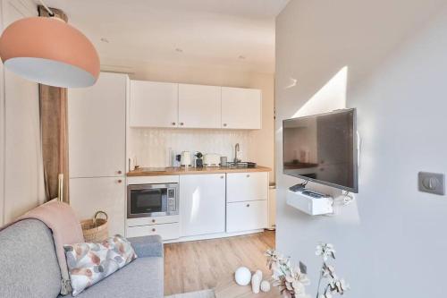un petit salon avec un canapé et une cuisine dans l'établissement Cozy and practical apt in 10th arr - PARIS, à Paris