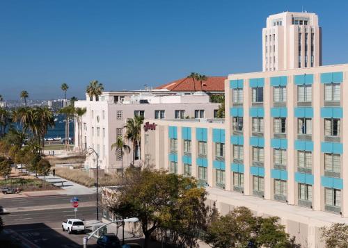 a large white building with blue windows on a city street at Hampton Inn San Diego Downtown in San Diego