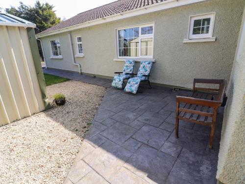 a patio with two chairs and a table and a fence at Gap of Dunloe in Derrylea