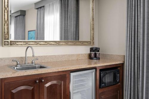 a kitchen with a sink and a microwave at Embassy Suites San Antonio Riverwalk-Downtown in San Antonio