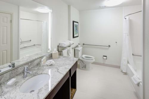 Baño blanco con 2 lavabos y aseo en Homewood Suites by Hilton Seattle-Tacoma Airport/Tukwila, en Tukwila