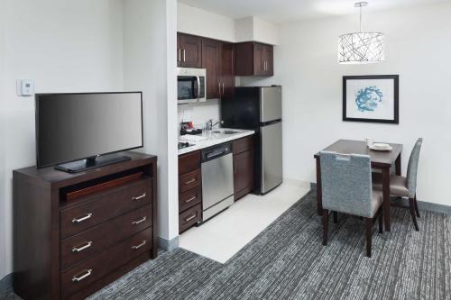a kitchen with a table and a television and a dining room at Homewood Suites by Hilton Seattle-Tacoma Airport/Tukwila in Tukwila
