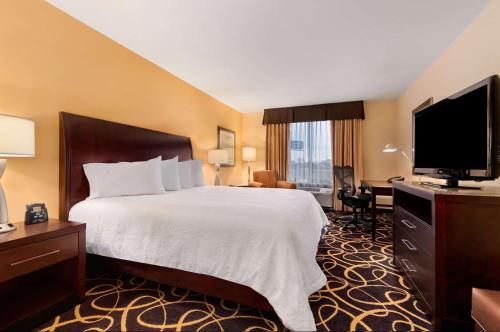 um quarto de hotel com uma cama grande e uma televisão em Hilton Garden Inn Shreveport Bossier City em Bossier City