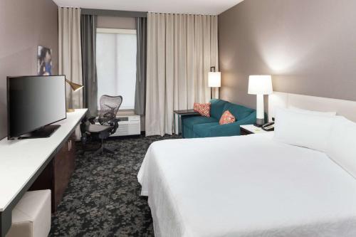 una camera d'albergo con letto e TV di Hilton Garden Inn Sacramento/South Natomas a Sacramento