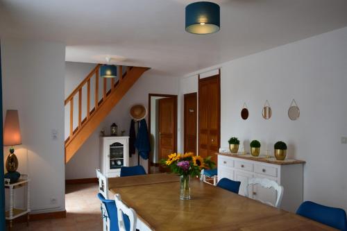 une cuisine et une salle à manger avec une table en bois et des chaises bleues dans l'établissement Baie du Mont Saint Michel, optez pour notre 