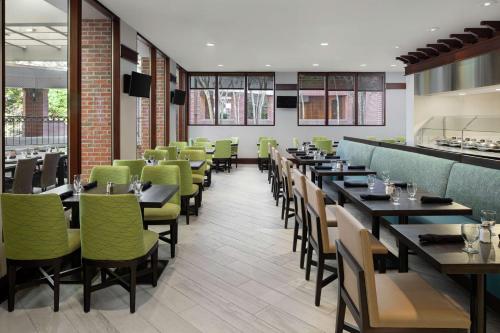 a dining room with tables and green chairs at DoubleTree Suites by Hilton Charlotte/SouthPark in Charlotte