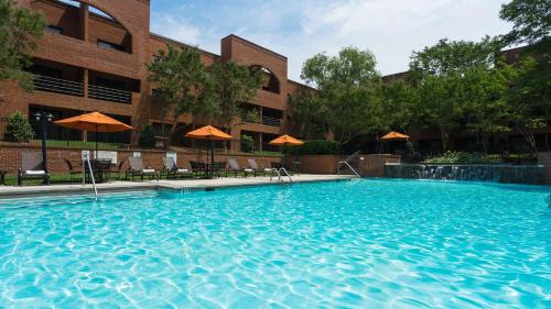 a large swimming pool in front of a building at DoubleTree Suites by Hilton Charlotte/SouthPark in Charlotte